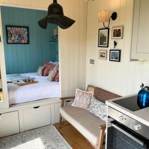 a small room with a bed and a kitchen at Daphne in Wedmore +19 photos