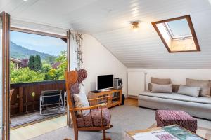 Una sala de estar con un sofá y un televisor y una ventana. en Ferienwohnung Haus Greif, en Garmisch-Partenkirchen