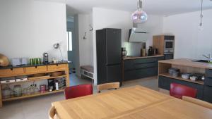 a kitchen with a wooden table and red chairs at Villa La Destenda in Labeaume +18 photos
