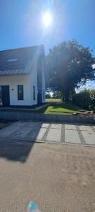 un edificio bianco con un albero di fronte di Vakantiewoning OpdeBaan a Kaatsheuvel