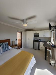 a bedroom with a bed and a ceiling fan at The Tides in Simonʼs Town