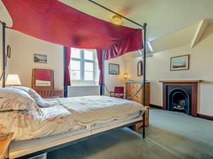 a bedroom with a canopy bed and a fireplace at 2 Bed in Lochgilphead AG577 in Kilmartin