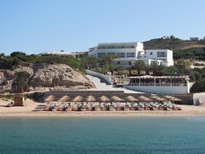 ProvatasGolden Milos Beach Ηouse by Domotel的一个带椅子和遮阳伞的海滩和一座建筑