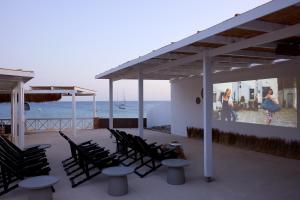 ProvatasGolden Milos Beach Ηouse by Domotel的俯瞰大海的庭院里摆放着几把椅子和桌子 更多37张照片