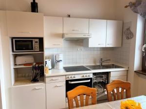 a kitchen with white cabinets and a stove top oven at Ferienpark im schönen Falkenstein 2 in Falkenstein