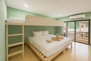 ein Schlafzimmer mit einem Etagenbett mit weißer Bettwäsche in der Unterkunft Casa Solana in Patong Beach