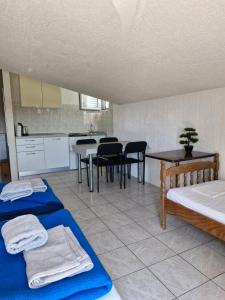 a room with two beds and a kitchen with a table at Apartmani Džapo in Srima +19 photos