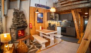 een keuken met een tafel en een open haard bij Slopeside Luppo - Original Log Cabin, Sauna, Ski 100m in Pyhätunturi