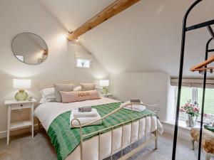 a bedroom with a bed with a green comforter at 2 Bed in Skipton 91296 in Bolton Bridge