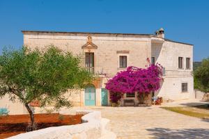 un grande edificio in mattoni con fiori rosa di fronte di Casa del Sud a Ostuni