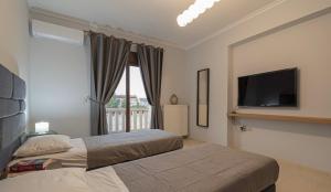 ein Schlafzimmer mit zwei Betten und einem Flachbildfernseher in der Unterkunft Villa Anastazia in Paralia Dionisiou