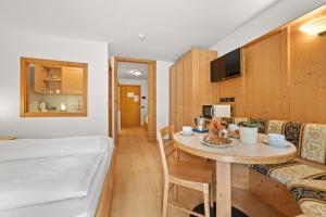 a room with a bed and a table in a room at Aparthotel Princess in Canazei