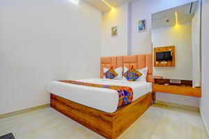 a bedroom with a large bed and a television at FabHotel Airport View- Near Airport in Ahmedabad