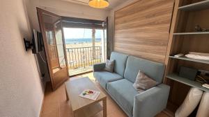 salon z niebieską kanapą i balkonem w obiekcie AR1B, Acogedor estudio a pie de playa w mieście Villajoyosa