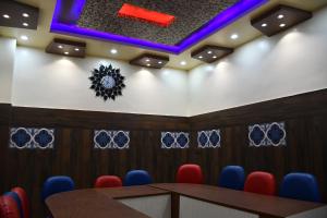 a conference room with a table and blue chairs at Hotel Sindhu in Bareilly