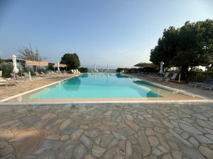 a large swimming pool with chairs and blue water at B&B Pacilita in Pianopoli