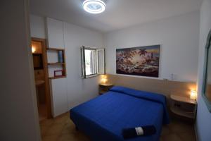a bedroom with a blue bed and a window at Villa MEMA in Bisceglie