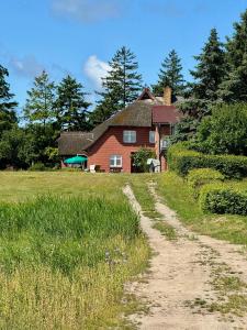 a dirt road in front of a red house at Ferienwohnung Krull in Wustrow