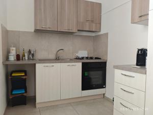 a kitchen with white cabinets and a sink and a stove at sosta modicana in Modica