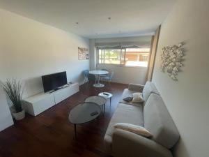 a living room with a couch and a tv at Precioso Apartamento en la Playa de Illa de Arousa in Isla de Arosa