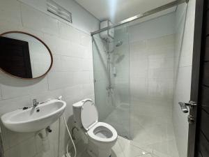 a bathroom with a shower and a toilet and a sink at Kubu Taraya in Jimbaran