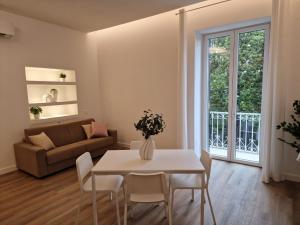 a living room with a table and chairs and a couch at De Angelis Apartments - GOLD in Sant'Agnello