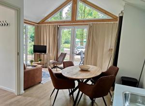 a living room with a wooden table and chairs at Vakantiepark Bergsehaak in Haaksbergen