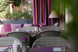 a table with wicker chairs and a table with purpleitures at La Place Boutique Hotel in Antibes