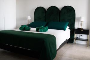 a green and white bed with two teddy bears on it at Marisabella Suite Spa 4 in Bari +16 photos