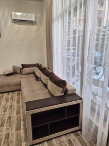 a couch in a living room with a large window at Студио Лазур с Безплатен Паркинг in Pomorie