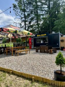 a park with benches and tables and a food truck at Noclegi Sarenka in Murzasichle +32 photos
