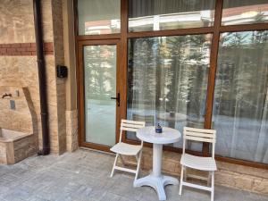 a white table and two chairs on a patio at Студио Лазур с Безплатен Паркинг in Pomorie