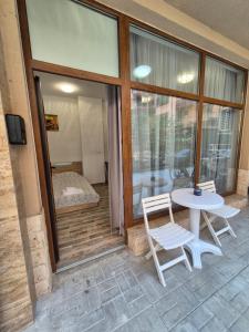 a patio with a table and two chairs and a window at Студио Лазур с Безплатен Паркинг in Pomorie