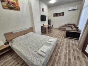 a living room with a bed and a couch at Студио Лазур с Безплатен Паркинг in Pomorie
