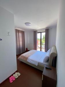 a bedroom with a large bed and a window at Vila Loris in Voskopojë +27 photos