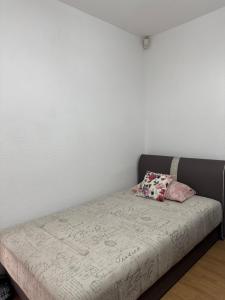 a bed with two pillows on it in a room at Apartman Stan na dan Happy Family Bihać in Ribić