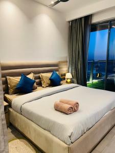 a bedroom with a large bed with blue pillows at Eden Suite - 30th floor in Noida