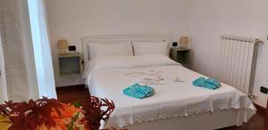 Un dormitorio con una cama blanca con dos toallas encima. en Appartamento Mandiri, en San Casciano in Val di Pesa