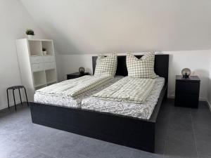 a bedroom with a black bed with two pillows at Ferienwohnung Reinsdorf in Büddenstedt