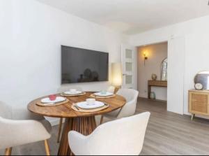 a dining room with a wooden table and white chairs at Apartament La Fleca in Sant Antoni de Calonge