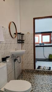 a bathroom with a toilet and a sink and a mirror at Cena Homestay in Mantaak
