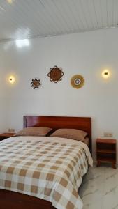 a bedroom with a bed with a checkered blanket at Cena Homestay in Mantaak