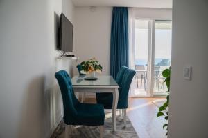 a dining room with a table and chairs and a window at Suite Apartment Sveti Stefan in Sveti Stefan