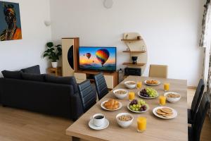 a living room with a table with plates of food at Appartement climatisé et cozy-C1 in Abomey-Calavi