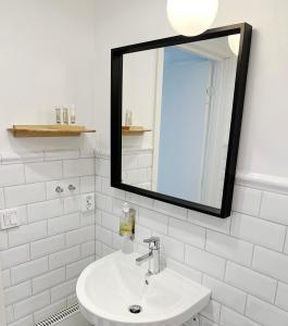 a white bathroom with a mirror and a sink at Hotell Norra Tullen tidigare Adas Hotell in Östhammar