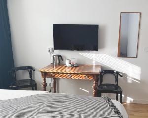 a bedroom with a desk with a television and two chairs at Hotell Norra Tullen tidigare Adas Hotell in Östhammar +6 photos