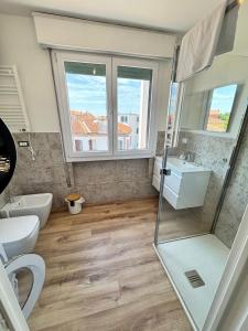 a bathroom with a toilet sink and a window at Bulldog Venice Apartment in Venice-Lido +22 photos