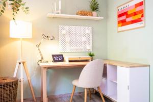a desk with a chair and a lamp at StayTime - Canopy Loft in Dresden