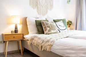 a bedroom with a bed with pillows and a night stand at StayTime - Canopy Loft in Dresden