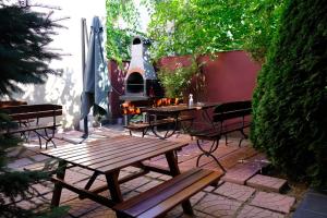 a patio with a wooden table and chairs and a grill at Vila Iulia in Eforie Nord